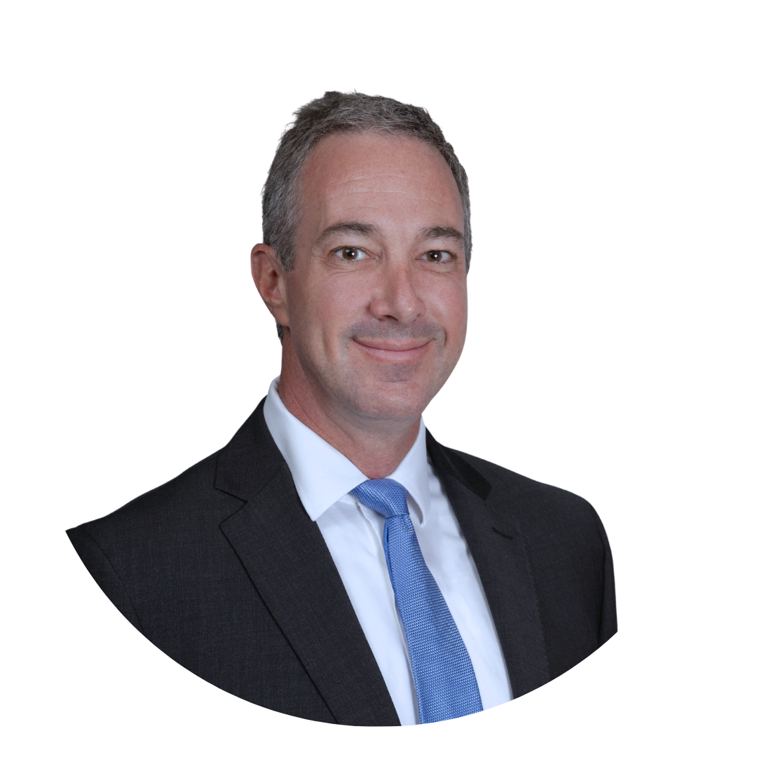 A man with gray hair wearing a black suit and a light blue tie, smiling in a professional headshot against a white background.