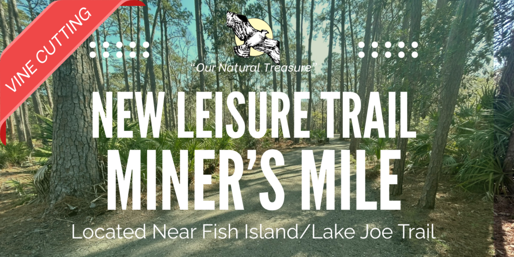 A scenic trail surrounded by trees, labeled as 'New Leisure Trail: Miner's Mile.' The image features a banner stating 'Vine Cutting' in the top left corner. The background shows a natural landscape near Fish Island and Lake Joe Trail.